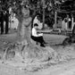 Black and white street photography, woman reading under shade of a tree, Mallorca, 2010