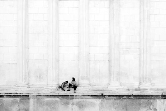 Maison carrée, Nimes, France, couple. From Eric Schneider's 'Street' photography series. Black and white photography wall art for homes, offices, hospitals, hotels, restaurants bars and cafes. An extensive collection for collectors, art buyers, interior designers and individuals.. 